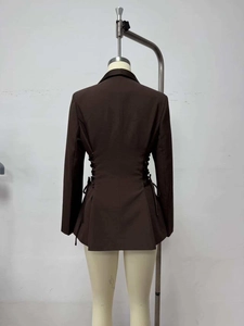 Detail view showing black lace-up corset design on the back of a slim fit brown blazer jacket