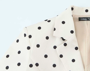 Detailed view of the black polka dot blazer collar with internal brand label and lining