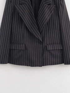 Close-up of pinstripe blazer featuring notch lapels and classic black and white stripes