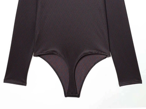 Detailed view of dark brown textured fabric and stitching on a long-sleeve bodysuit