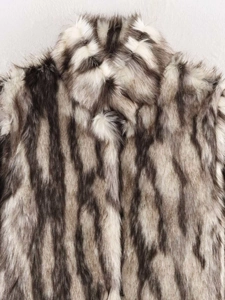 Detailed view of plush faux fur texture with grey and black stripes on the collar area