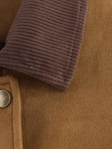 Detail of faux suede jacket with corduroy collar and vintage brass metal button