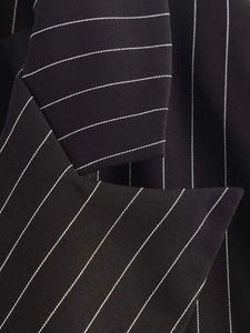 Detailed macro view of the striped lapel and fabric texture of a black blazer
