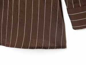 Detail view of brown striped shirt showing precise stitching on the hem and woven texture