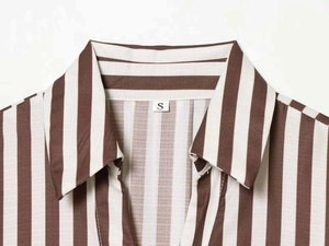 Close-up of the V-neck collar and size S tag on a brown and white striped shirt