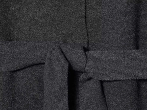 Detailed close-up of charcoal grey knit fabric with a soft knotted tie design