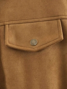 Detailed close-up of brown faux suede jacket featuring vintage metal button and utility pocket