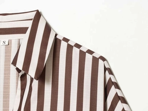 Detailed close-up of brown and white vertical striped shirt collar with size S tag
