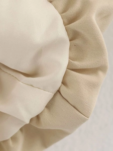 Detail of minimalist beige canvas fabric with soft pleated texture and woven details