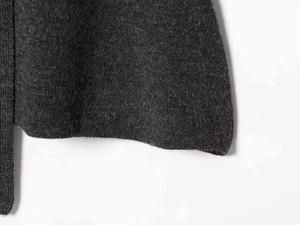 Close-up of charcoal grey knit fabric texture showing fine woolen yarn and soft finish