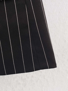 Detailed view of black and white pinstripe twill fabric texture on a blazer