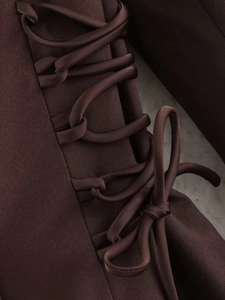 Detail view of a chocolate brown satin blazer with elegant side lace-up drawstring bow