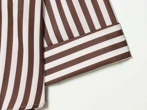 Macro shot of brown and white striped v-neck shirt sleeves with high quality stitching