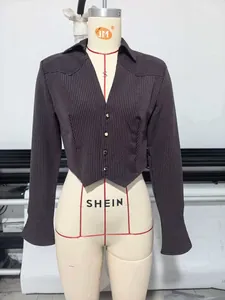 Detail showing grey striped short shirt with shoulder pads and gold buttons
