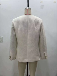 Vue détaillée du dos d'une veste en tweed blanc cassé avec texture tissée et coupe élégante