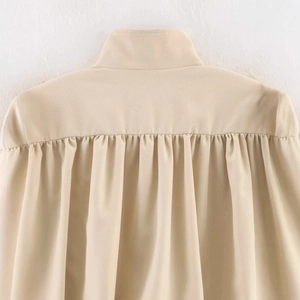 Beige high-neck pleated jacket featuring detailed back ruching and soft chiffon texture