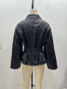 Back view of a black faux leather jacket featuring a belted waist and peplum hem detail