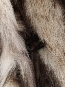 Detailed macro view of the fluffy faux fur texture and black braided drawstring closure