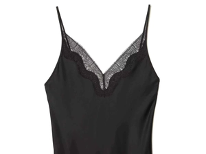 Detailed close-up of a black satin camisole with deep V-neck and delicate eyelash lace trim