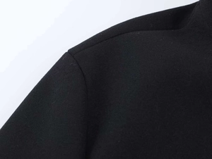 Close-up of the high-quality black wool blend fabric texture on the jacket shoulder