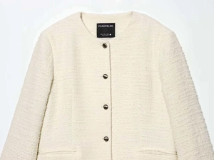 Détail d'une veste en tweed blanc avec col rond et boutons bordés d'or élégants
