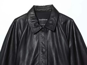 Detailed view of the brand label and inner neckline of a premium black leather jacket