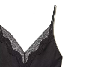 Close-up of black satin camisole featuring delicate floral lace trim on the V-neckline