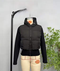 Detail of black hooded puffer vest with quilted panels and front zipper closure