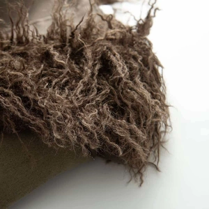 Macro shot of dark brown curly faux fur texture on retro suede coat detail