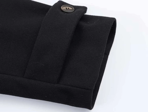 Macro shot of sleeve cuff details with amber button on black wool jacket for women