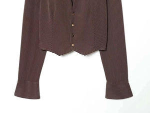 Detail of dark brown pinstripe shirt showing shoulder pads and metallic buttons
