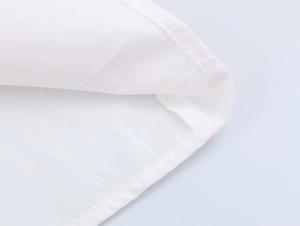 Close-up of fine stitching and hem detail on a premium white poplin shirt fabric