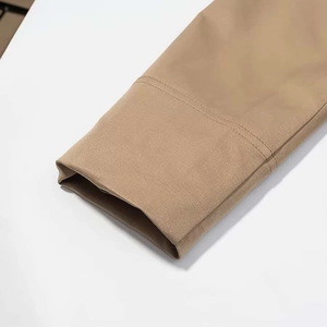 Detailed macro view of khaki twill fabric texture and double-stitch sewing on jacket cuff