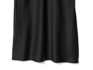 Close-up of black satin dress hem showing smooth silk texture and soft drape detail