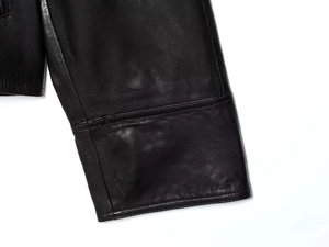 Detailed close-up of premium black leather jacket sleeve with high-quality stitching