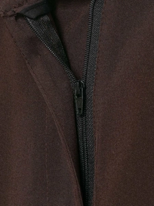 Close-up of the smooth zipper closure and stitching on dark brown wide-leg trousers