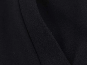 Close-up detail of high-quality black fine knit fabric texture on autumn jacket