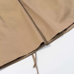 Detailed close-up of khaki jacket hem showing high-quality twill fabric and drawstring tie