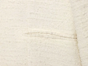 Détail macro du tissu en tweed blanc de haute qualité sur une veste à manches longues