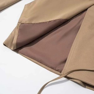 Detail of khaki short jacket showing hem stitching and smooth dark inner lining fabric