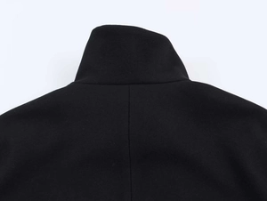 Detail view of the black stand-up collar and smooth back seam of this stylish jacket