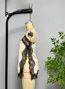 Detail of cream lace camisole top featuring elegant black scalloped contrast trim