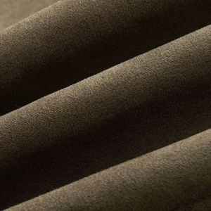 Macro shot of olive green suede fabric showing soft texture and fringe decorative details