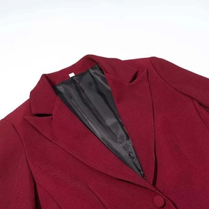 Détail du blazer bordeaux avec texture tissée, revers cranté et doublure noire lisse