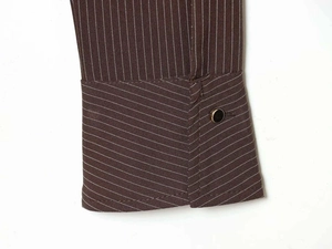 Close-up of striped shirt cuff with brown pinstripes and golden-rimmed black button