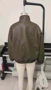Vista posteriore del bomber in ecopelle verde scuro con orlo elastico e dettaglio cucitura a V
