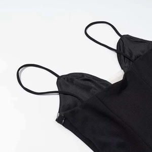 Détail de robe noire à col en V avec fines bretelles spaghetti et fermeture éclair latérale
