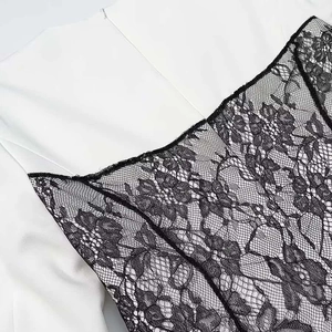 Close-up of elegant black lace stitching on white fabric for women dress garment