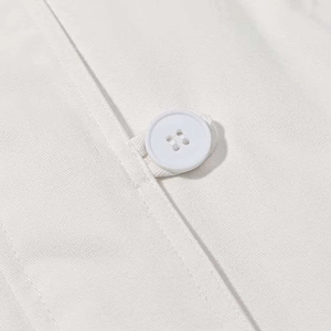 Detail of white hooded jacket showing high-quality twill fabric and a classic four-hole button