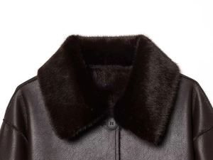 Close-up of deep brown leather jacket featuring a plush faux fur collar and black buttons